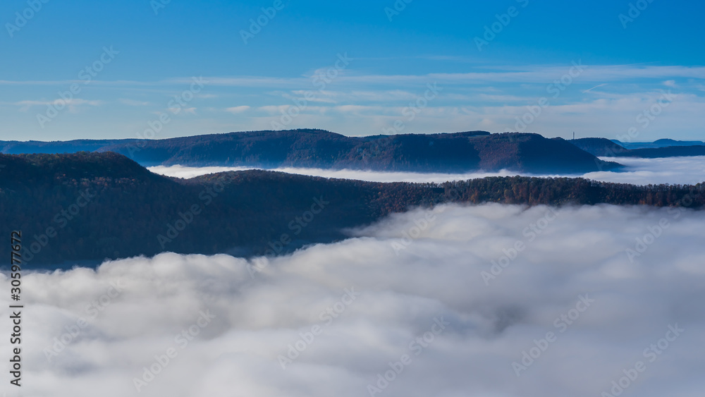 Germany, Amazing aerial view above fog clouds in valley of swabian jura nature landscape on sunny day with blue sky near stuttgart