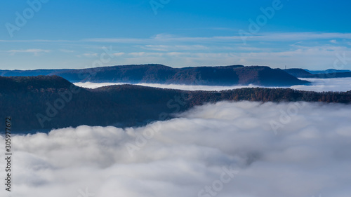 Germany  Amazing aerial view above fog clouds in valley of swabian jura nature landscape on sunny day with blue sky near stuttgart