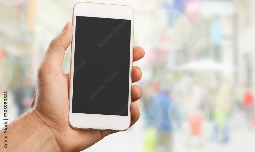 Hand holding smartphone  on blurred city background