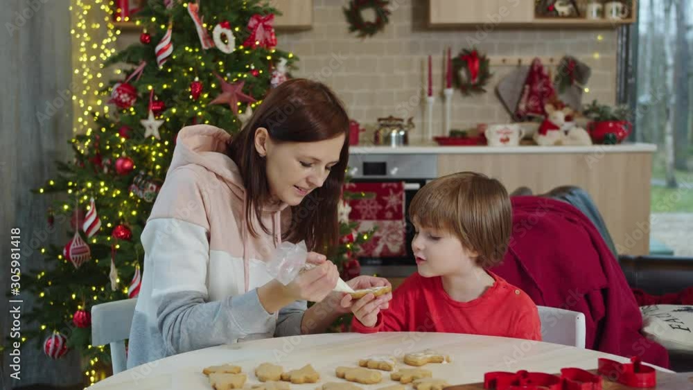 mom and son decorate christmas cookies mom and son decorate christmas cookies