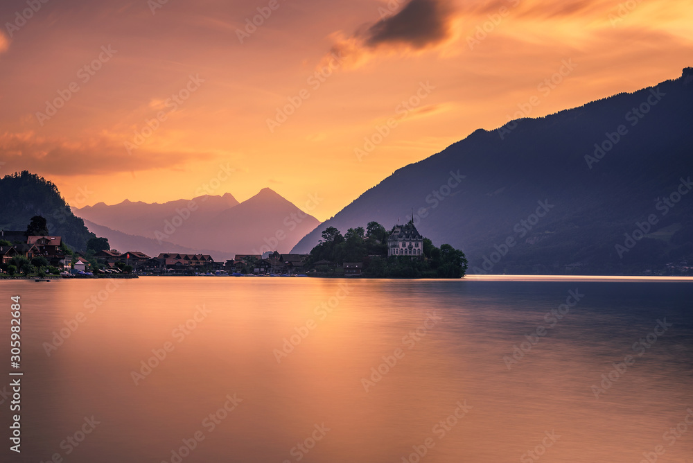 Sunset above Iseltwald peninsula and former castle in Switzerland