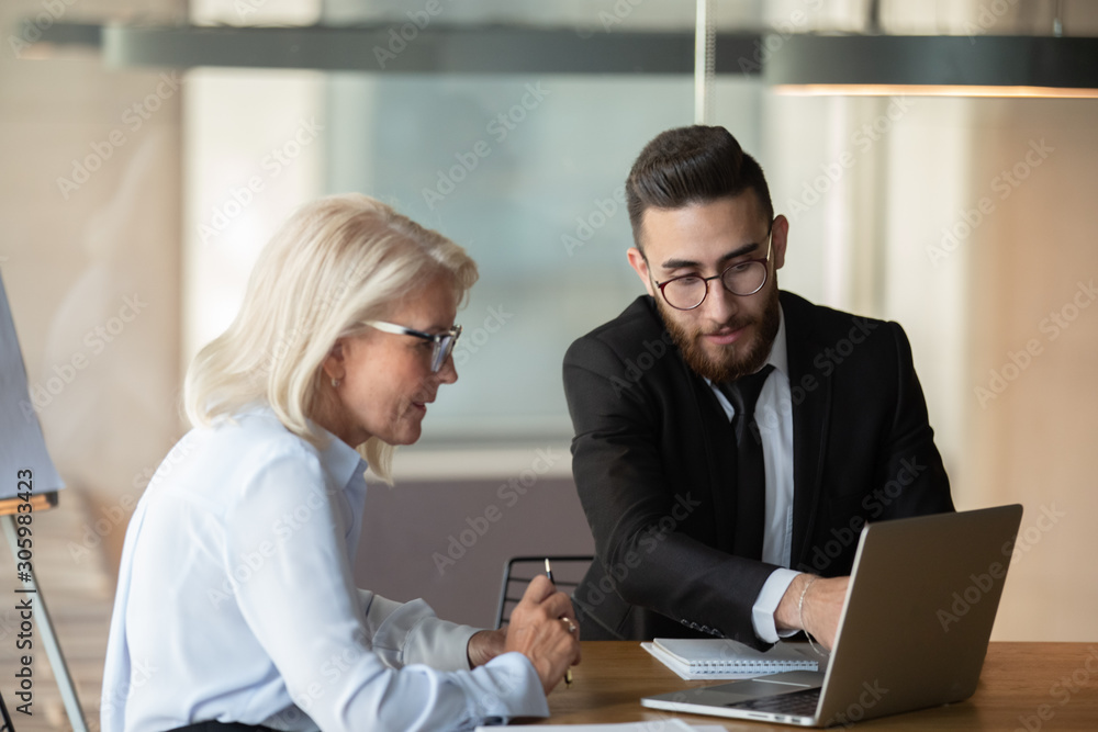 Arabian male employee share ideas with woman colleague at meeting Arabian male employee share ideas with woman colleague at meeting