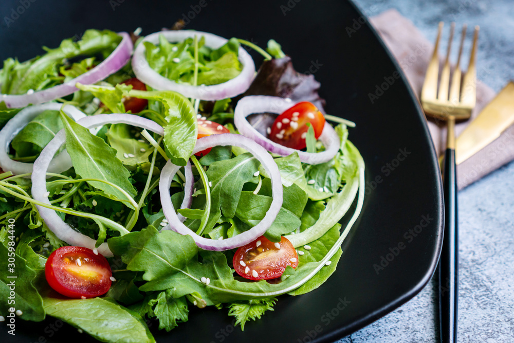 Eat green concept with organic fresh vegetable salad in ceramic plate on black background.. Eat green concept with organic fresh vegetable salad in ceramic plate on black background..
