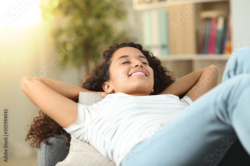 Happy woman resting lying on a couch at home photo