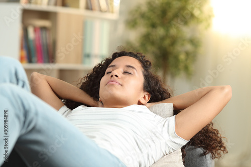 Serious woman resting lying on a couch at home photo