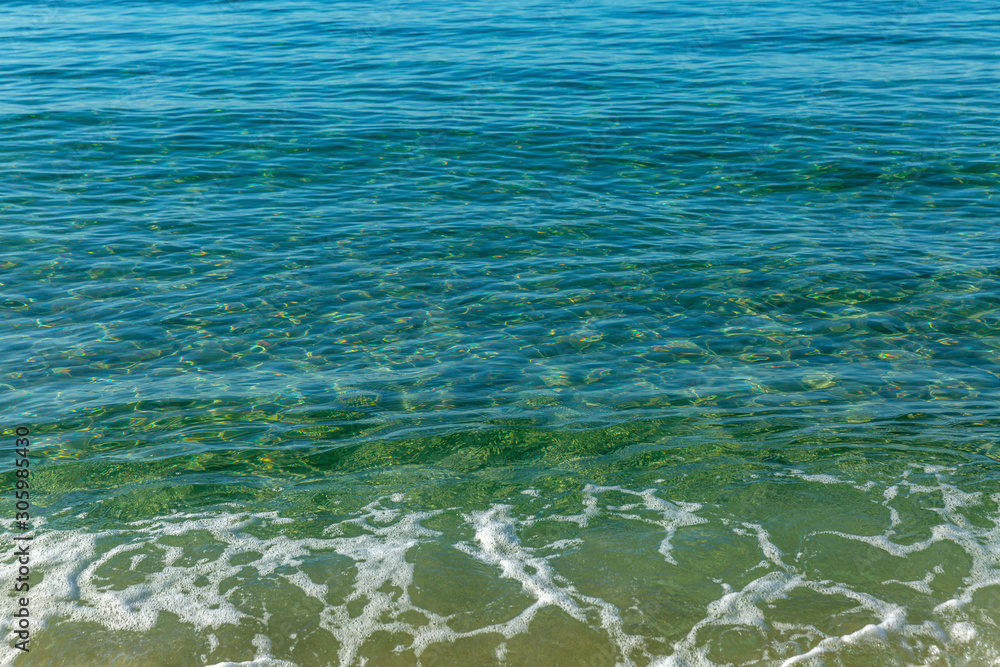 Transparent turquoise surface of the sea. Relax and calm. Background. Space for text.