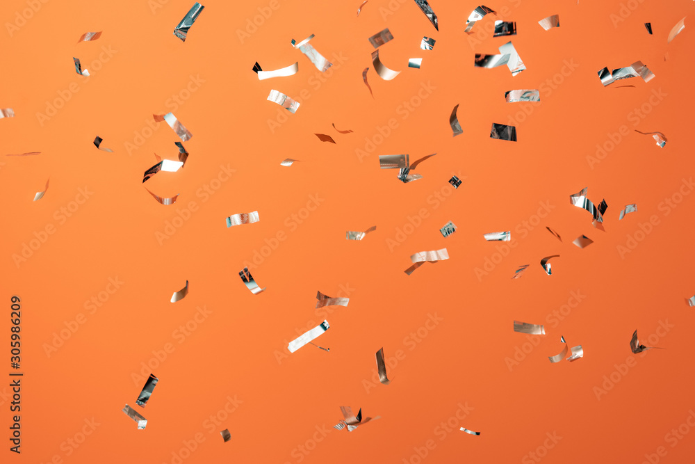 shiny silver confetti on orange background - obrazy, fototapety, plakaty 
