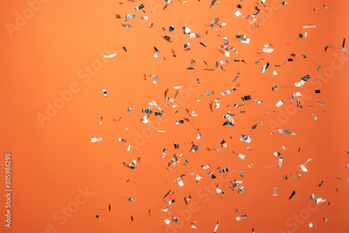 shiny silver confetti on orange background