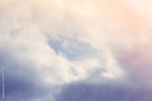 Blue sky with clouds illuminated by the rays of the sun. Background