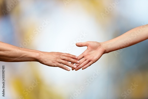 Hands reaching out and touching each other on a bokeh background © BillionPhotos.com