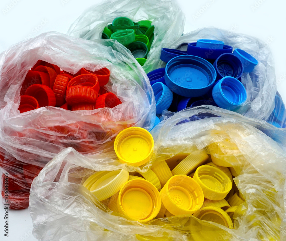 Colorful plastic bottle caps sorted by colors in transparent single use ...