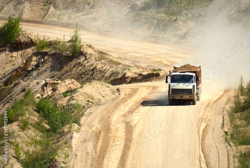 Dump truck transports sand and other minerals in the mining quarry.