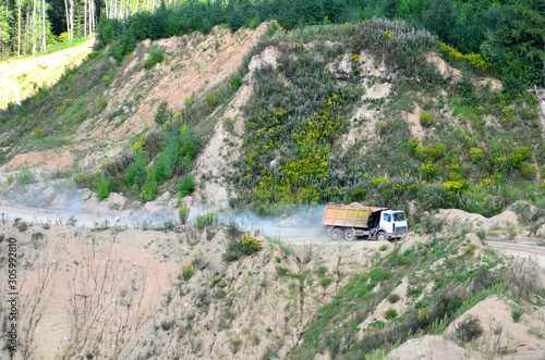 Dump truck transports sand and other minerals in the mining quarry. photo