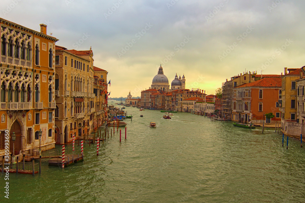 Breathtaking landscape of Grand Canal with turquoise water. It's the main water-traffic corridor in the city. Buildings and palazzo along the canal. Basilica Santa Maria della Salute in the background