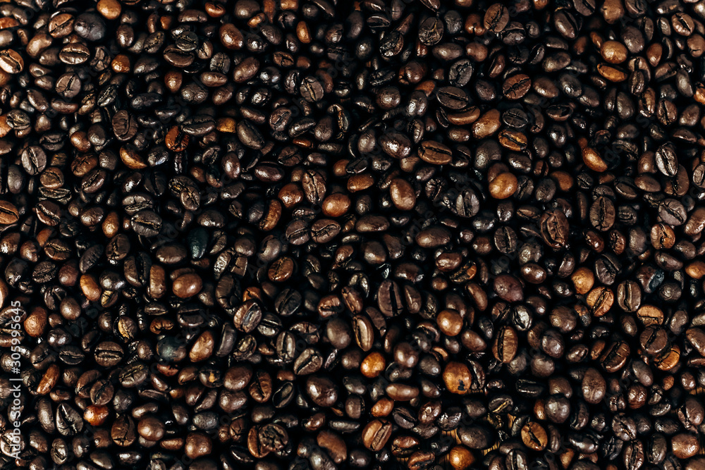 a lot of coffee beans on a wooden background. background and space for text