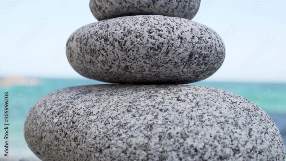 Stone tower on the beach against the azure sea. Beautiful rocks on the background. Peace and tranquility. Clean blue sky. Soul balance. Cobblestone sculptures. Stone tower on the beach against the azure sea. Beautiful rocks on the background. Peace and tranquility. Clean blue sky. Soul balance. Cobblestone sculptures.