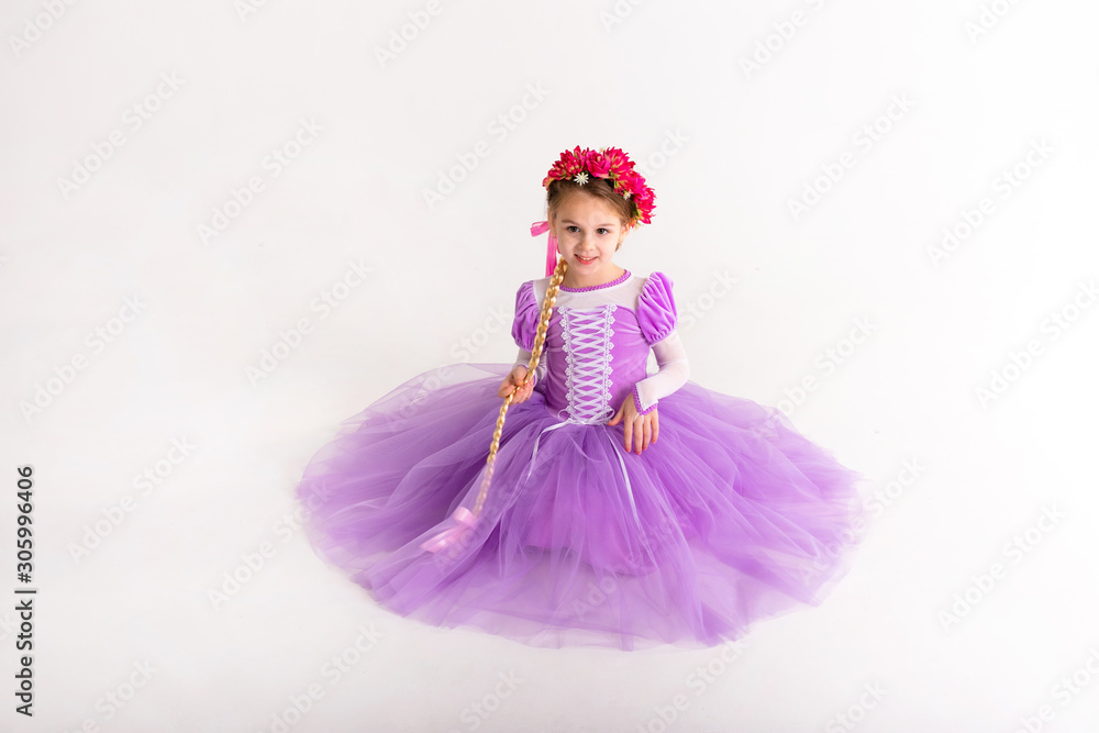 Little blonde girl wearing purple fairy princess dress on white background. Kids costume for new year party