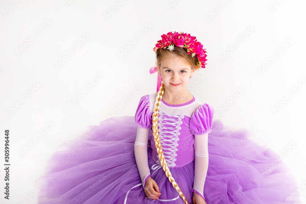 Little blonde girl wearing purple fairy princess dress on white background. Kids costume for new year party Little blonde girl wearing purple fairy princess dress on white background. Kids costume for new year party
