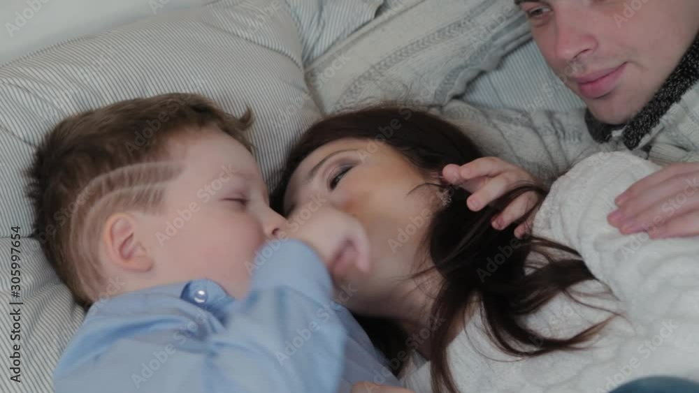 Happy family on the bed in modern interior. Happy family on the bed in modern interior.