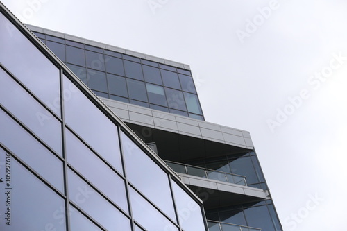 Abstract business modern city urban futuristic architecture background, motion blur, reflection in glass of high rise skyscraper facade, toned blue picture with bokeh. Real estate concept