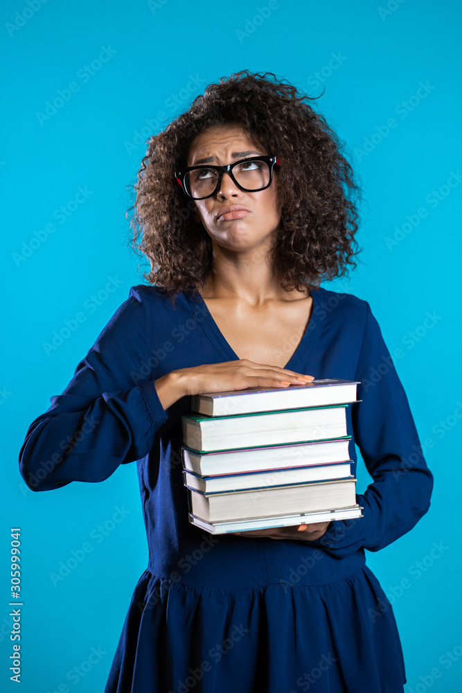 African student is dissatisfied with amount of homework and books. Girl with books, she is annoyed, discouraged frustrated by studies. African student is dissatisfied with amount of homework and books. Girl with books, she is annoyed, discouraged frustrated by studies.