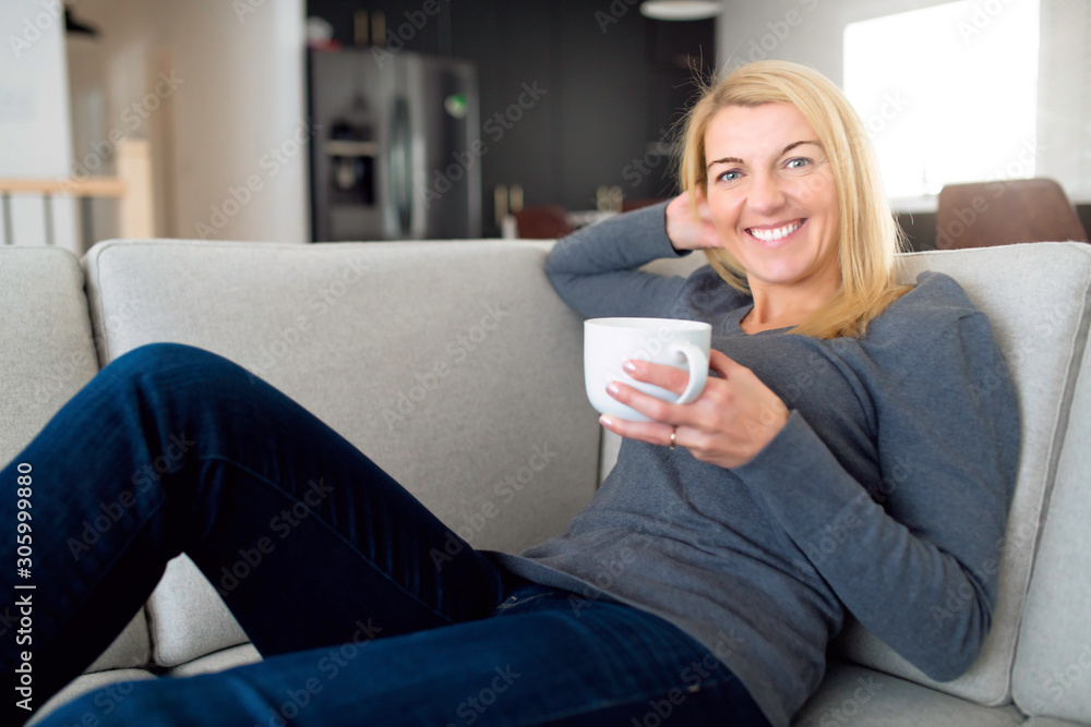 Relaxed woman enjoying rest on comfortable sofa with coffee, calm attractive girl relaxing on couch Relaxed woman enjoying rest on comfortable sofa with coffee, calm attractive girl relaxing on couch