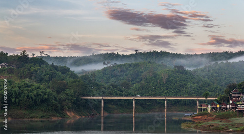 the bridge over the river in morning with fog and view of mist at Sangkhlaburi  Focus at the bridge.