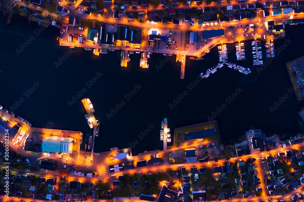 Obraz premium Fantastic aerial evening cityscape of Klaksvik town with glowing pier, ships and boats, Bordoy island, Faroe islands, Denmark. Landscape photography