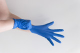 Doctor putting on protective blue gloves