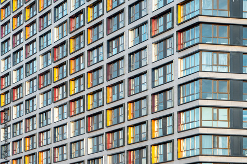 Muticolor facade of a residential multi-storey building with large windows. Modern architecture. Real estate in a big city. Background from the wall of the house.