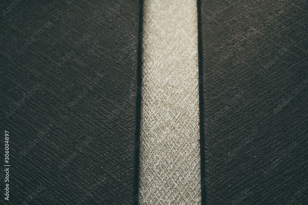 Fototapeta premium Close-up of customer grade realistic black and white plastic high detail textured leather imitation background surface with vertical line segment