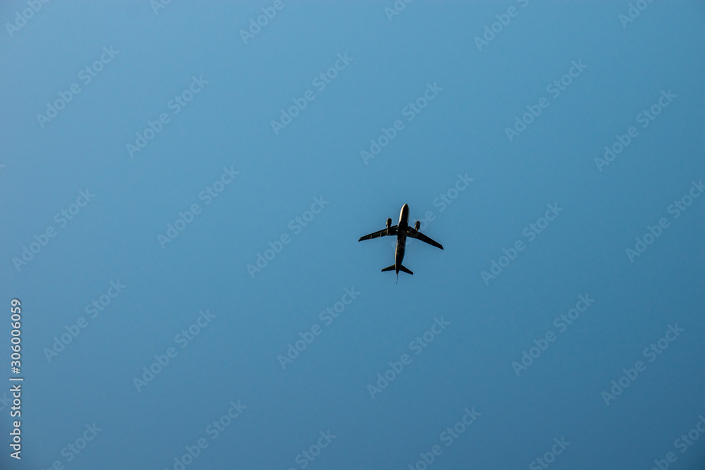 Airplane in the clear sky at sunset. Airliner landing or taking off.