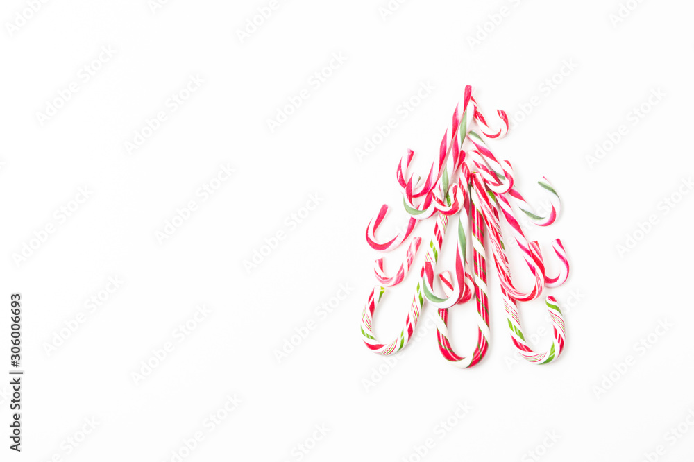 Christmas tree shape made of candy canes on white background. Top view Christmas tree shape made of candy canes on white background. Top view