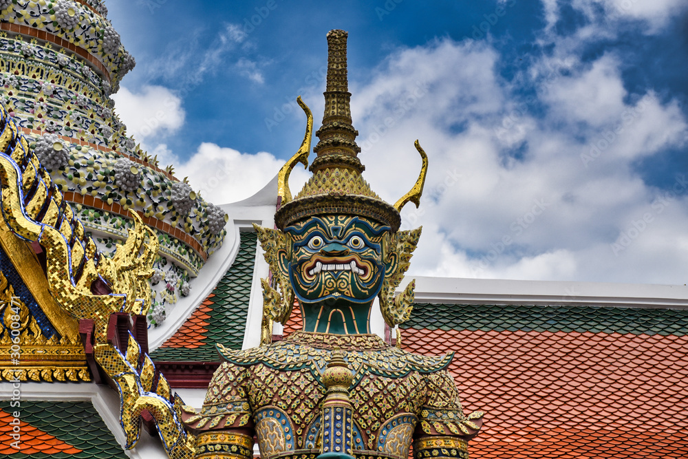 Giant Yak, Yaksha statue with large teeth, piercing eye with sword in hand protecting and guarding the famous Temple of the Emerald Buddha or Wat Phra Kaew from evil spirits
