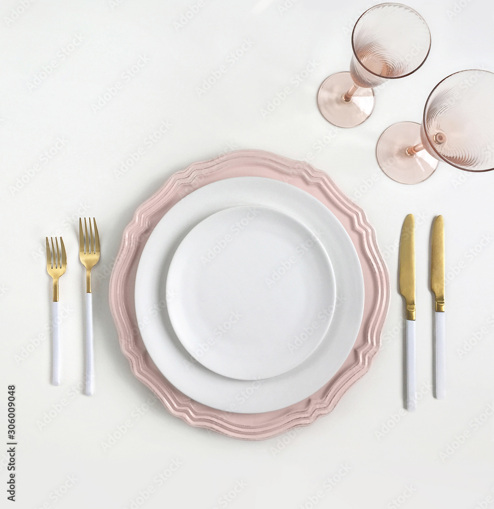 New luxury white and pink ceramic plate, golden cutlery view from above on a isolated background. Top view..Knife and fork for a festive table for a wedding, birthday or party.