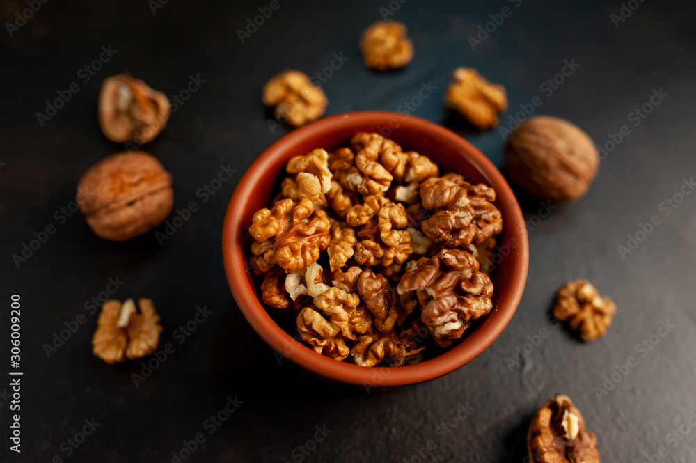 Walnuts. Kernels and whole nuts on a stone background Walnuts. Kernels and whole nuts on a stone background