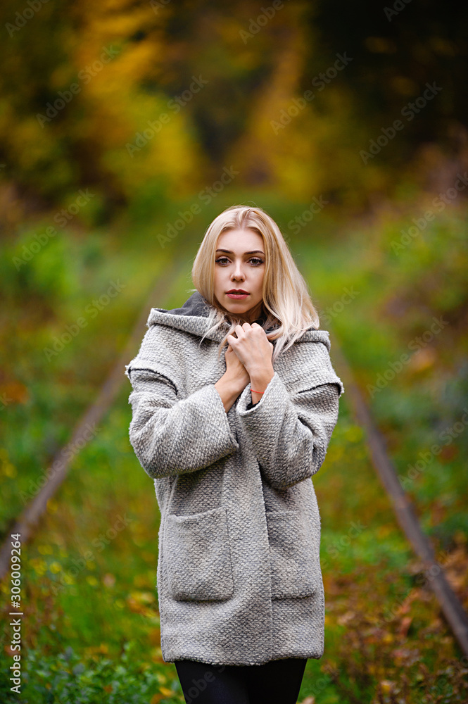 Attractive blonde posing in yellow and red leaves in autumn in the forest Attractive blonde posing in yellow and red leaves in autumn in the forest