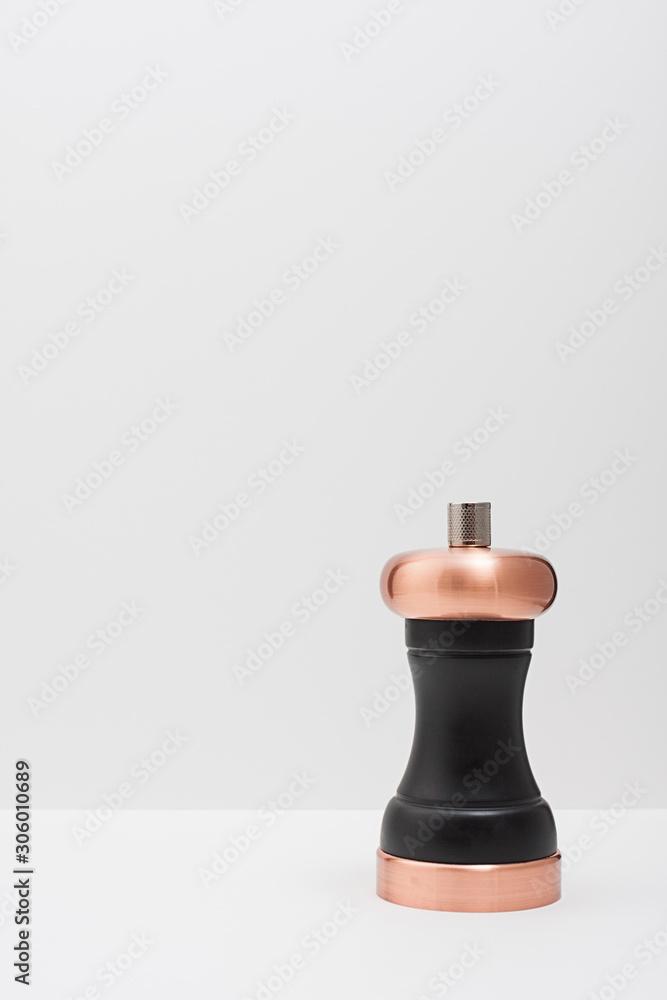Black pepper mill with copper inserts on white background. Black pepper mill with copper inserts on white background.