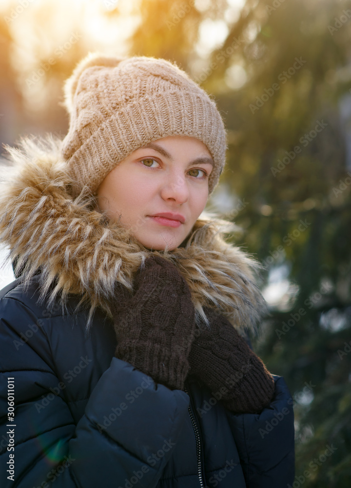 portrait of beautiful girl in winter jacket and wool cap under falling snow portrait of beautiful girl in winter jacket and wool cap under falling snow