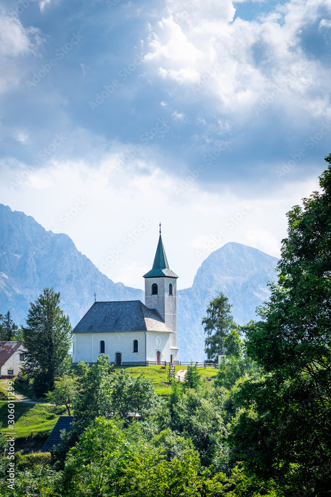 Church Cerkev Sveti Duh with mountain range Kamnik–Savinja Alps