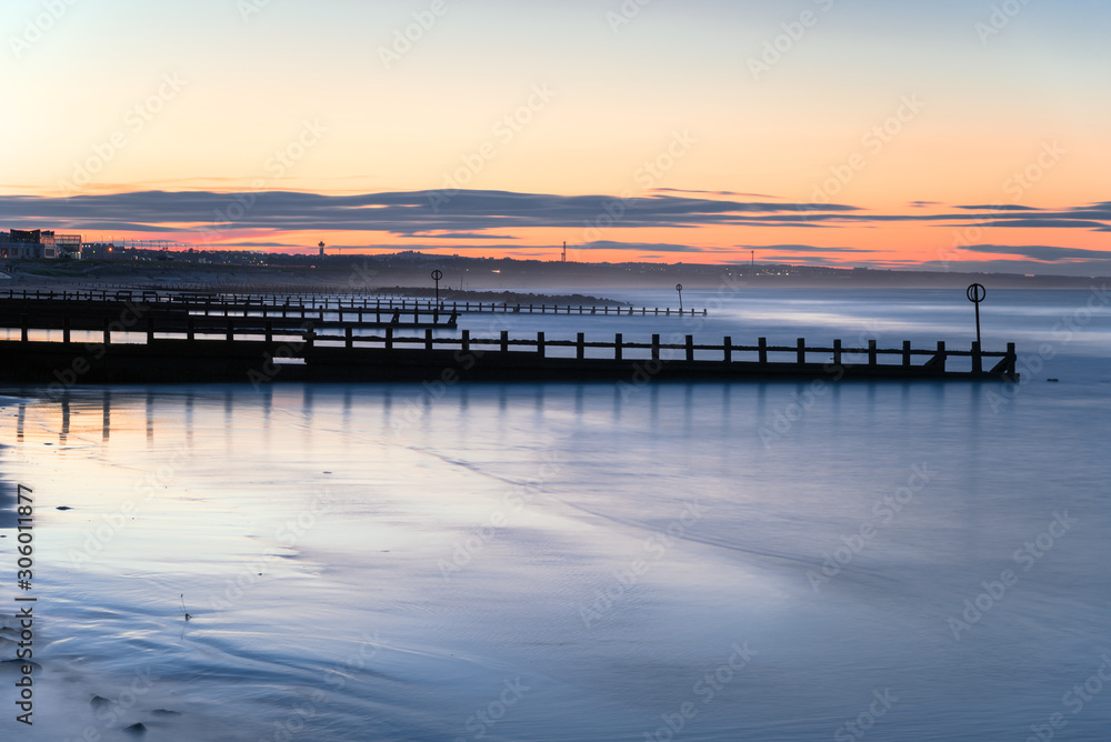 Long exposure of beach with groynes at twilight. Aberdeen, Scotland, UK.