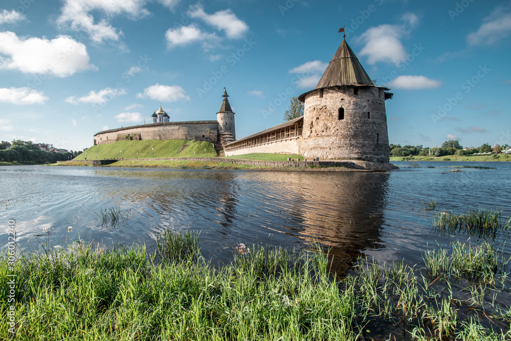 Pskov Kremlin against the backdrop of a bright blue sky in the summer. Ancient Russian architecture. Stone Watchtower.