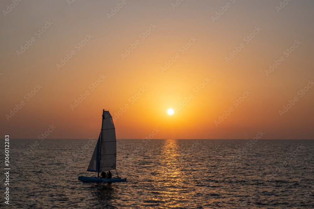 Tandem sailing board with two windsurfing athletes at sea in calm at sunset in Israel