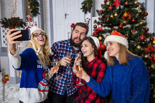 Christmas time company fun mood smiling photogenic people making selfie in winter holidays festive decorated interior background