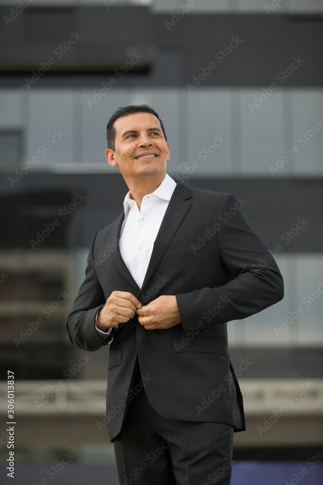 Handsome Latino executive man leaving office, talking on the phone and wearing casimir suit Handsome Latino executive man leaving office, talking on the phone and wearing casimir suit