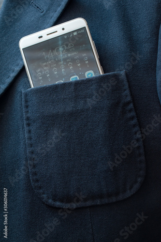 Blue jacket chest pocket with a white mobile phone