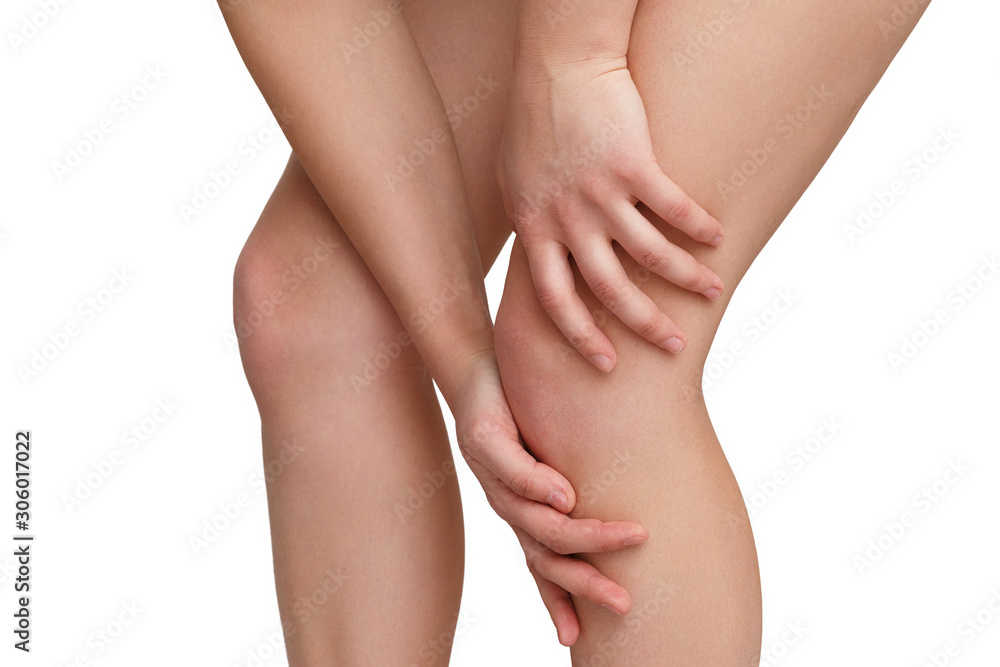 a woman stands with her hands around her knee on one of her legs. isolated on white background