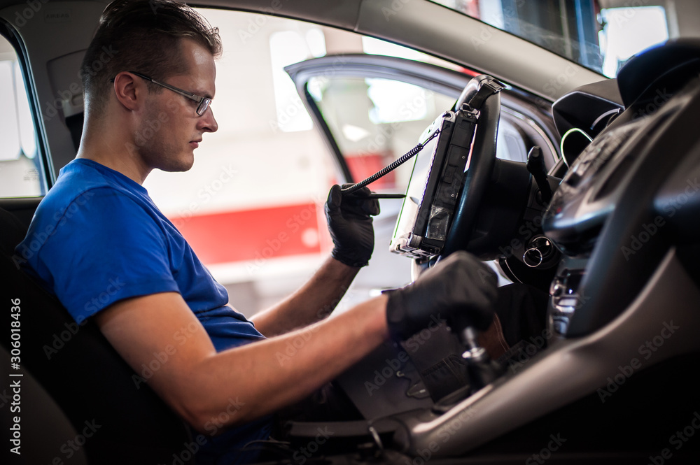 Automobile computer diagnosis. Car mechanic repairer looks for engine failure Automobile computer diagnosis. Car mechanic repairer looks for engine failure