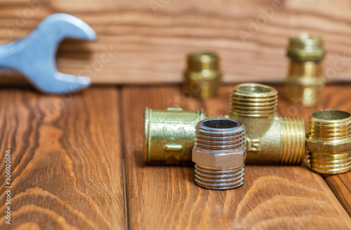 Set of brass fittings is often used for water and gas installations on background of tools