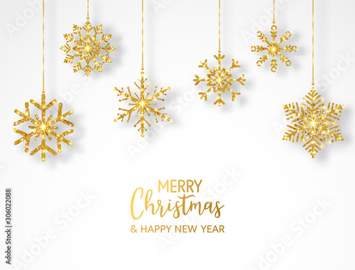 Merry Christmas greeting card with hanging glitter snowflakes and hand lettering. Bright gold baubles on white background. Luxury holiday design elements. Vector illustration